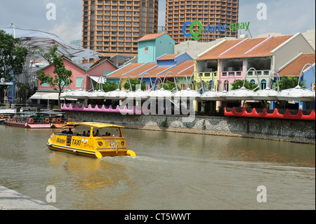 Il giallo di un viaggio in barca lungo il fiume vicino a Clarke Quay, Singapore, Sud-est asiatico. Foto Stock