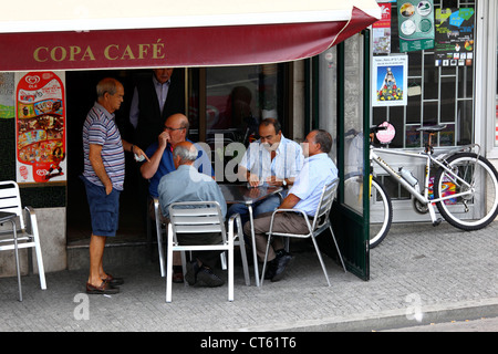 Gli uomini locali carte da gioco al di fuori strada tipica cafe , Viana do Castelo, Portogallo settentrionale Foto Stock