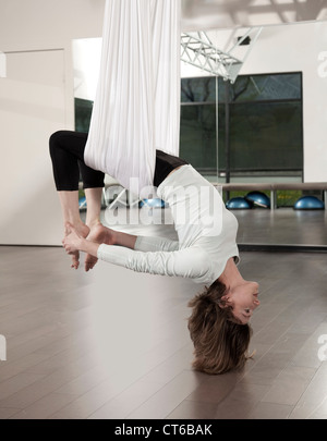 Donna facendo anti gravity yoga esercitarsi nel centro fitness. Foto Stock