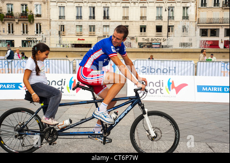 Parigi, Francia - Francese i bambini in palestra Classe, cercando attrezzature per disabili, biciclette tandem ciclismo a "Rencontres FES Handisport'. Foto Stock