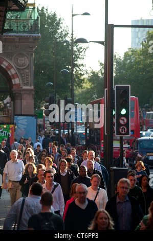 I pedoni a camminare lungo una strada trafficata nel centro della città di Londra, Inghilterra. Foto Stock