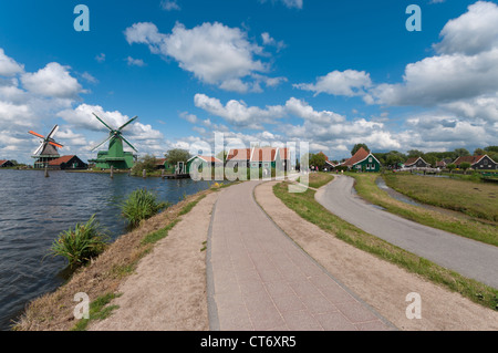 Strada lungo l'acqua con i famosi mulini a vento di Zaanse Schans Foto Stock