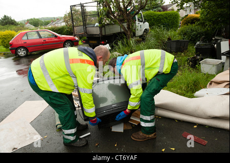 Consiglio il carico dei lavoratori un televisore su di un carrello per lo smaltimento dopo le inondazioni che case danneggiate in Aberystwyth Giugno 2012 Foto Stock