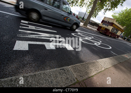 Un taxi nero guida lungo un Olympic Route Network (ORN) nel centro di Londra, nel Regno Unito, le corsie chiaramente segnalate, progettate per garantire che atleti, funzionari e personale chiave arrivino ai luoghi olimpici in modo efficiente e puntuale. Parte dei preparativi della città per ospitare i Giochi, l'ORN si estende su strade e strade principali, dando priorità al traffico olimpico per mantenere gli orari e il coordinamento degli eventi. Foto Stock