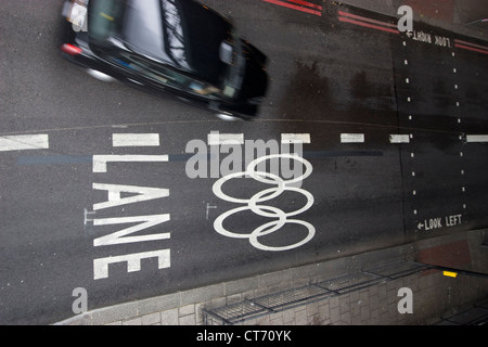 Un taxi nero guida lungo un Olympic Route Network (ORN) nel centro di Londra, nel Regno Unito, le corsie chiaramente segnalate, progettate per garantire che atleti, funzionari e personale chiave arrivino ai luoghi olimpici in modo efficiente e puntuale. Parte dei preparativi della città per ospitare i Giochi, l'ORN si estende su strade e strade principali, dando priorità al traffico olimpico per mantenere gli orari e il coordinamento degli eventi. Foto Stock