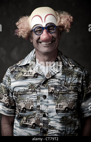 Ritratto di un uomo anziano che indossa la maschera da clown Foto Stock