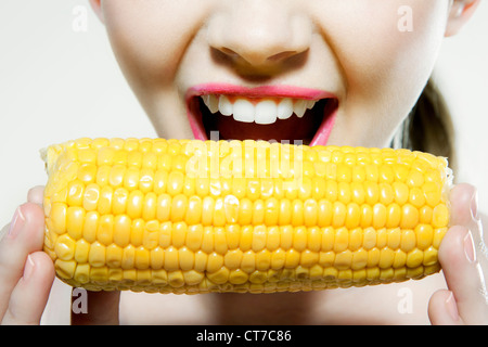 Giovane donna di mordere di tutoli di mais Foto Stock