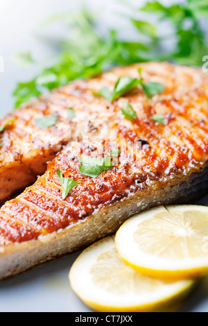 Croccante di salmone alla griglia bistecca con pomodori ciliegia e prezzemolo Foto Stock