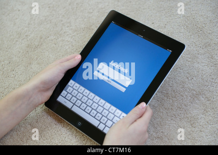 Ragazza con iPAD con Facebook login pagina sullo schermo Foto Stock