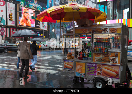 Cibo Tipico di vendita Carrello cucinato al momento hot dogs & pretzel nelle strade di Manhattan, New York City in caso di pioggia Foto Stock