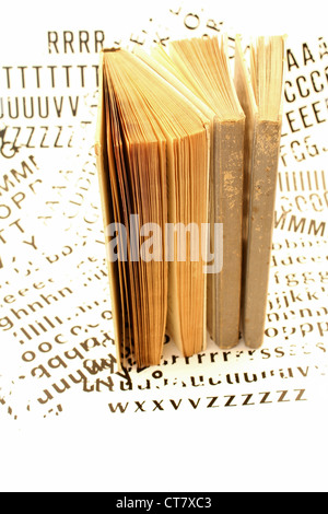 Tre libri vecchi contro un testo in bianco e nero dello sfondo. Foto Stock