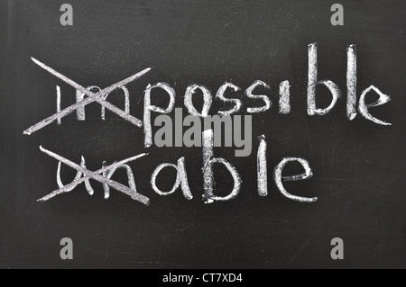 Pensare positivo concetto manoscritta su lavagna nera con modifica impossibile, impossibile parole Foto Stock