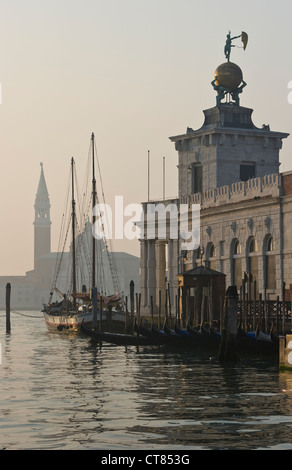 La galleria d'arte Punta della Dogana (di Tadao Ando) sul Canal Grande a Venezia, all'alba, con la torre di San Giorgio maggiore in lontananza Foto Stock