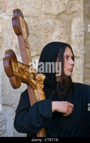 Pellegrini cristiani portano in tutta lungo la Via Dolorosa di Gerusalemme Foto Stock