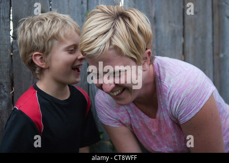 Dieci anni di vecchio ragazzo raccontando la sua madre una storia e la mamma ridere outloud. Foto Stock