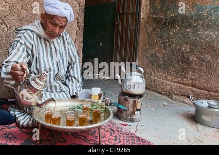 Tradizionali Berbere nonno versando il tè nel sud montagne Atlas, Marocco Foto Stock