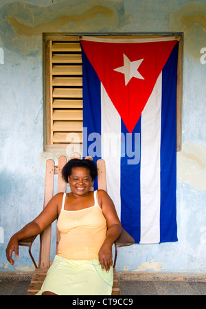 Donna sul portico con bandiera cubana, Viñales Cuba Foto Stock