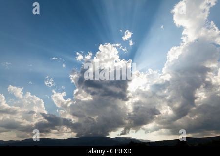 Light con il sole che tramonta dietro le nuvole Foto Stock