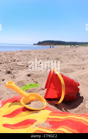 Colorato giocattoli da spiaggia e asciugamano in rive sabbiose di Panmure Island in Prince Edward Island, Canada Foto Stock