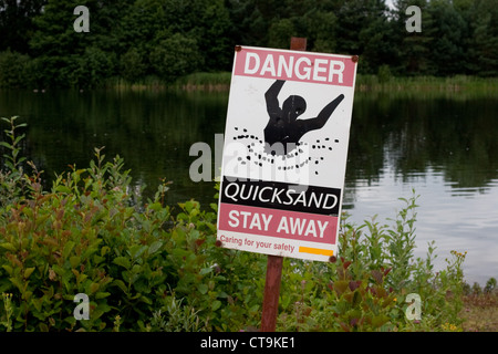 Pericolo di cartelli di sabbia mobile accanto al lago a Lynford, Norfolk Foto Stock
