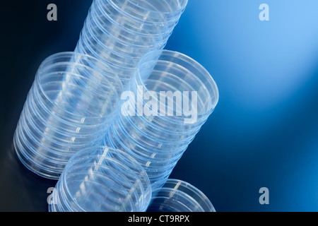 Diverse pile di vuoto piastre di Petri su uno sfondo blu. Foto Stock