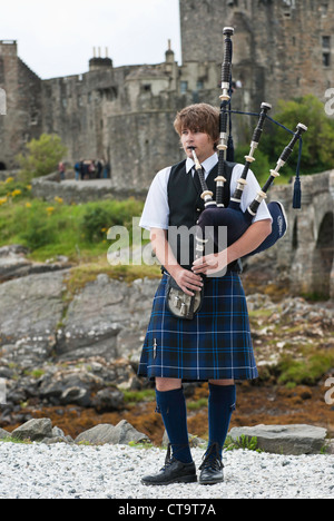 Lo scozzese indossando i tradizionali panni durante la riproduzione di cornamuse a Castello Eilean Donan Scozia UK. Foto Stock