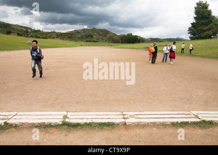 I turisti alla linea di partenza originale del Stadio Olimpico, Olympia, Grecia Foto Stock