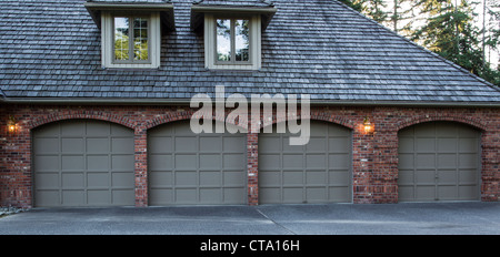 Quattro garage auto porte in legno e mattoni con alberi e il cielo in background Foto Stock