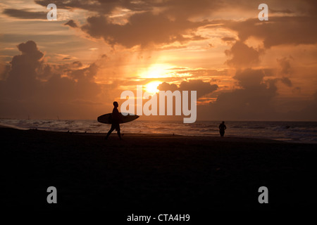 Un surfista stagliano contro il sole sul Surf City Beach , Topsail Island , North Carolina , USA Foto Stock