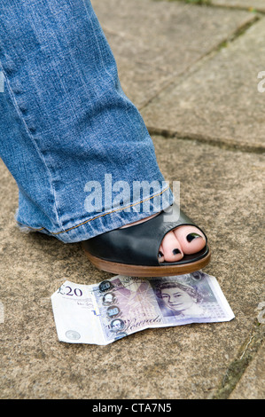 Close up dei womans piede su una ventina di Sterling Pound nota, concetto di perso e trovato, o fortunati. Foto Stock
