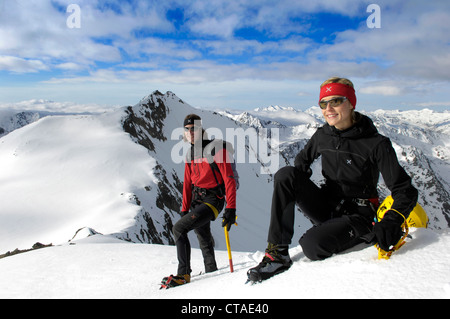 Due alpinisti in appoggio sul picco di montagna, Alto Adige, Trentino Alto Adige, Italia Foto Stock