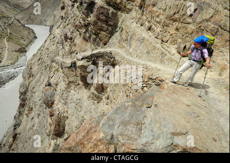 Donna che guarda in una gola tra Padum e Phuktal, Zanskar gamma traversa, Zanskar Range, Zanskar, Ladakh, Jammu e Kashmir Foto Stock