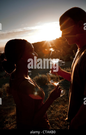 Uomo Donna und gustando un bicchiere di vino bianco a sun-set, Stellenbosch, Western Cape, Sud Africa Foto Stock