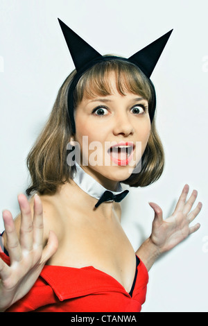 Giovane donna in costume di carnevale con le corna su sfondo bianco Foto Stock