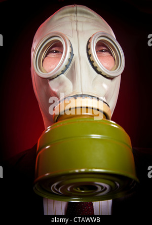 Persona in una maschera a gas su uno sfondo scuro Foto Stock