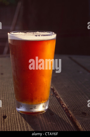 Una pinta di birra seduti su un tavolo da picnic. Foto Stock