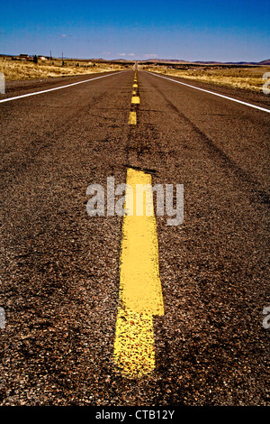 Un traffico di giallo stripe divide un lungo rettilineo vuoto in autostrada in Arizona. Foto Stock