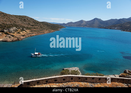 Barca per gite visto dalla fortezza veneziana, isola di Spinalonga, prefettura di Lasithi, Golfo di Mirabella, Creta, Grecia Foto Stock