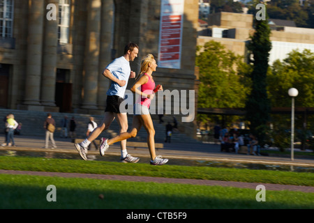 Coppia giovane jogging, superiore il giardino del castello, Staatstheater di Stoccarda, Baden Wurttemberg, Germania Foto Stock