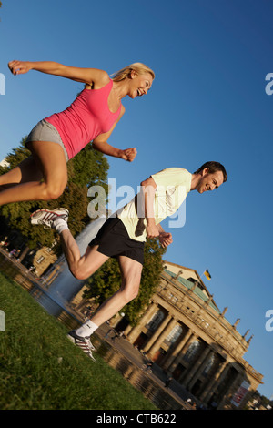 Coppia giovane jogging, superiore i giardini del castello, il Teatro Nazionale, il Teatro di Stato di Stoccarda, Baden Wurttemberg, Germania Foto Stock