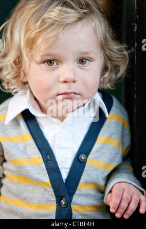 Elegante piccolo ragazzo con capelli ondulati Foto Stock