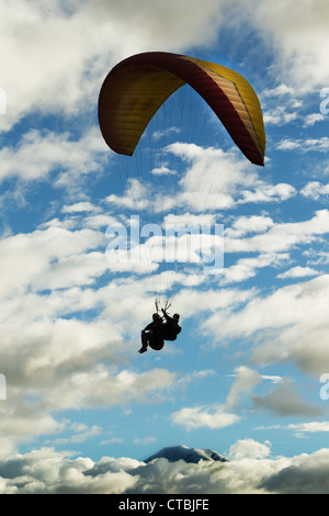 Parapendio in tandem contro il cielo nuvoloso Ande ecuadoriane in background Vulcano Chimborazo Foto Stock