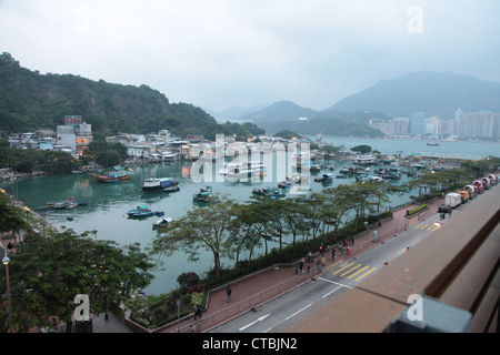 Si tratta di una foto di Yau Tong Villaggio Porto di Hong Kong. Siamo in grado di vedere qualche pesce e imbarcazioni private. Possiamo vedere la strada e gli alberi come ben Foto Stock