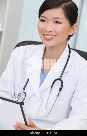 Un Cinese femmina asiatica medico usando un computer tablet nel suo ospedale di office Foto Stock