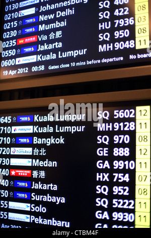 Elettronica di bordo partenza segno con destinazioni dei voli presso l'Aeroporto Changi di Singapore. Foto Stock