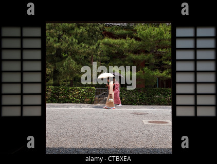 Due donne giapponesi rivestite di kimono con ombrelli per ombreggiarle dal sole, nel tempio buddista Zen di Daitoku-ji, Kyoto, Giappone Foto Stock