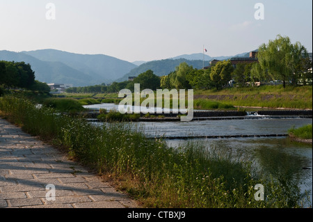 Il tranquillo sentiero lungo le rive del fiume Kamo a Kyoto, Giappone, un luogo popolare e tranquillo per passeggiare, andare in bicicletta o fare un picnic Foto Stock