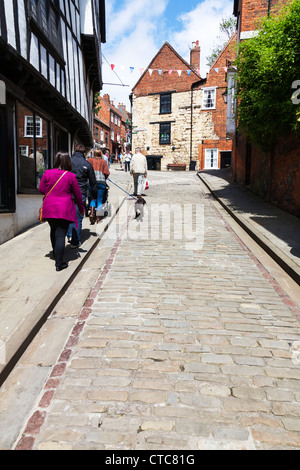 Inghilterra, ripida collina è una meta turistica molto street nel centro storico della città di Lincoln coronato la più grande strada in Gran Bretagna Foto Stock