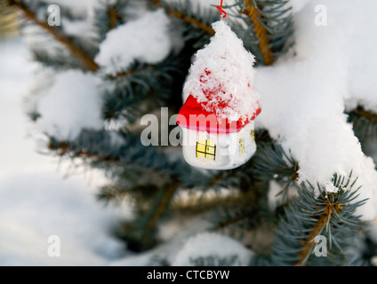 A Natale decorazione ad albero (vetro casa bianca con il tetto rosso) sulla struttura ad albero per esterno Foto Stock