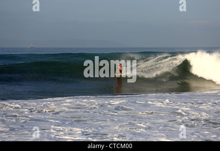 Corpo uomo surf una grande onda nel West Java, Indonesia. Foto Stock